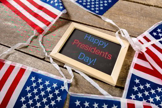 the text happy presidents day written in a chalkboard and a flag of the United States photo