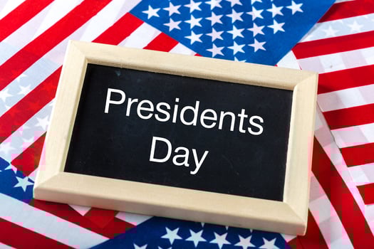 the text happy presidents day written in a chalkboard and a flag of the United States photo