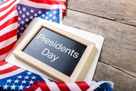 the text happy presidents day written in a chalkboard and a flag of the United States photo