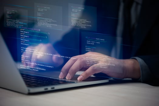 A person in a suit is typing on a laptop photo
