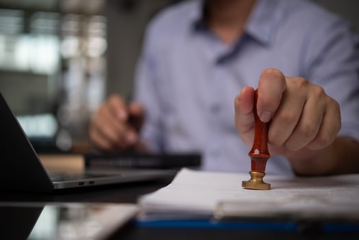 A person holding a pen and writing on a piece of paper photo