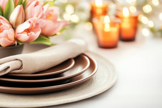 Elegant dining setup featuring brown plates, pink flowers, and warm candles for a cozy dinner ambiance photo