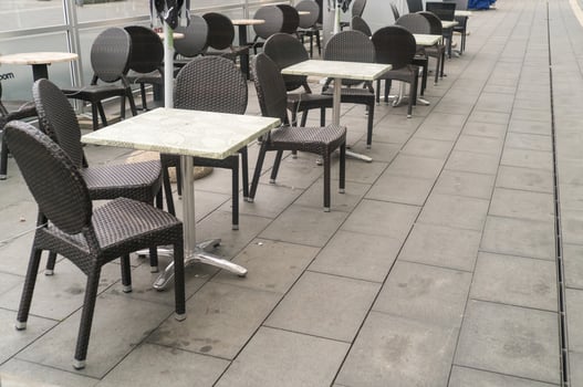 Empty outdoor cafe tables and chairs during rain photo