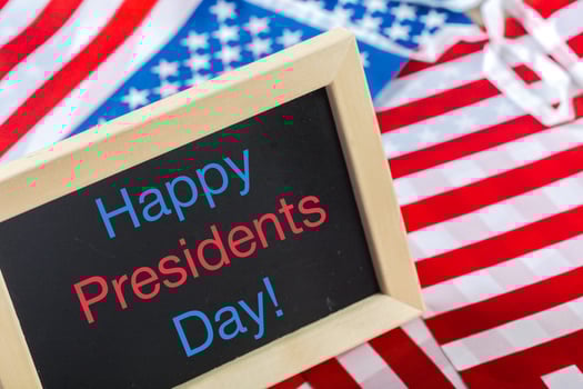the text happy presidents day written in a chalkboard and a flag of the United States photo