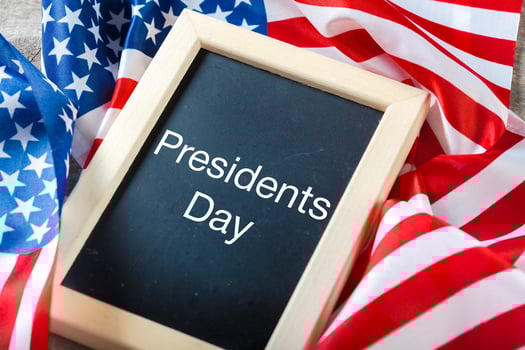 the text happy presidents day written in a chalkboard and a flag of the United States photo