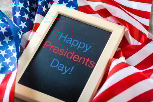 the text happy presidents day written in a chalkboard and a flag of the United States photo