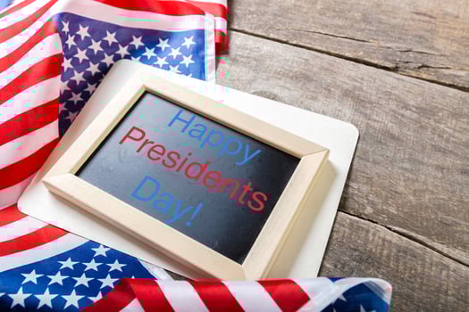 the text happy presidents day written in a chalkboard and a flag of the United States photo