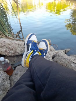 A person's feet on a rock near a body of water photo