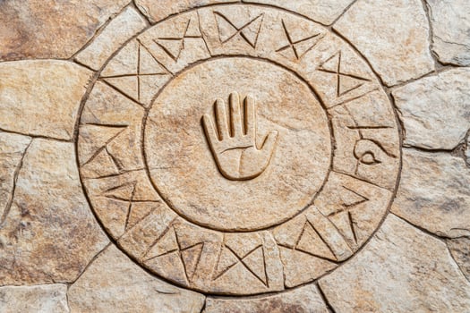 ancient carved stone symbol with hand design photo