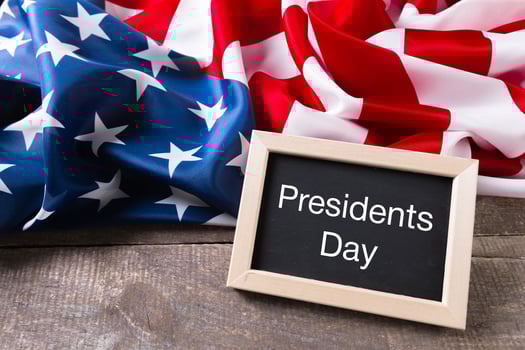 the text happy presidents day written in a chalkboard and a flag of the United States photo