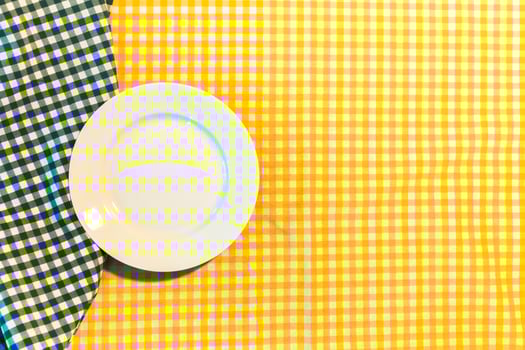 the plate on yellow checkered table cloth photo