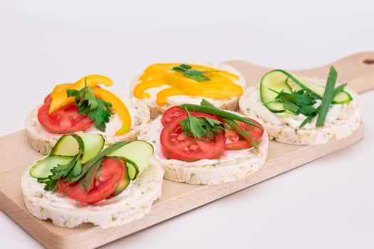 Different Vegan Rice Cake Sandwiches with Fresh Tomato, Yellow Paprika and Greens on Wooden Cutting Board. Vegetarian Diet Food. Quick and Healthy Sandwiches. Crispbread with Fresh Fillings photo