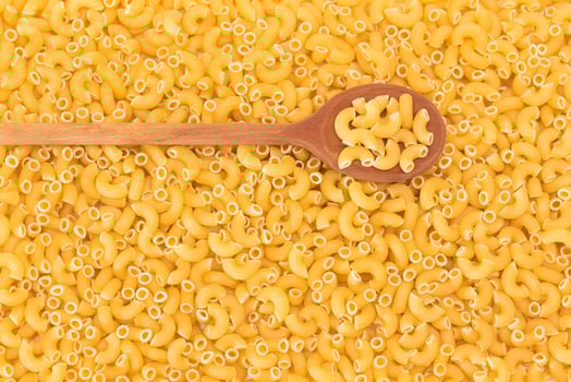 Uncooked Chifferi Rigati Pasta Background with Wooden Spoon. Fat and Unhealthy Food. Classic Dry Macaroni. Italian Culture and Cuisine. Raw Pasta photo