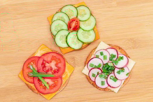 Different Cracker Sandwiches with Tomato, Cucumber, Radish and Cheese on Cutting Board. Easy Breakfast. Diet Food. Quick and Healthy Sandwiches. Crispbread with Tasty Filling. Healthy Dietary Snack photo