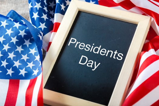 the text happy presidents day written in a chalkboard and a flag of the United States photo