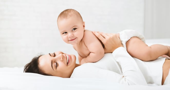 Family having fun together. Mom and baby boy in diaper playing in bedroom, panorama, copy space photo