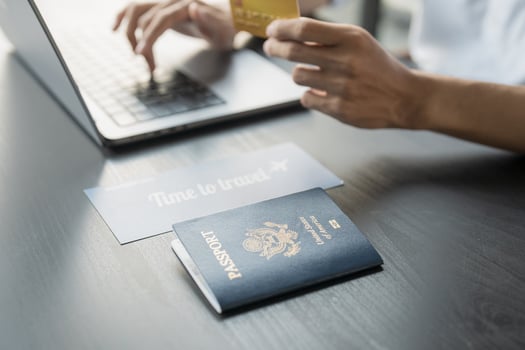 Hand Man Online booking and buying plane tickets using laptop phone and credit card Planning trip travel vacation with passport and ticket photo