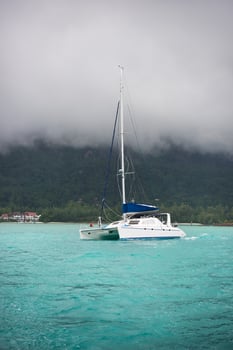 Recreational Yacht in fog at the coast of Seychelles photo