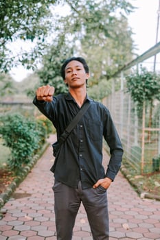 Southeast Asian man raising his fist with a determined expression photo