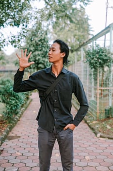 Southeast Asian man holding his cheek with a pained expression, indicating a toothache. photo