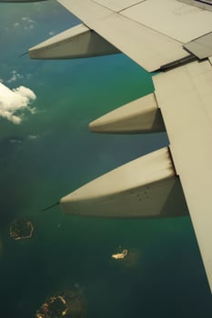 Photos View of airplane wing turbines over small islands. In the photo from inside the plane. Holiday events