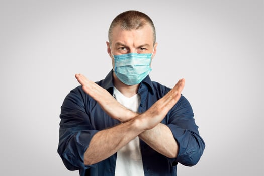 Coronavirus Restrictions. Man In Protective Medical Mask Crossing Hands Forbidding Something Standing Over Gray Studio Background. Panorama, Copy Space photo