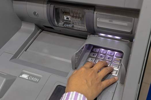 Close up view of a female hand pressing number keys on Automated Teller Machine or ATM machine photo
