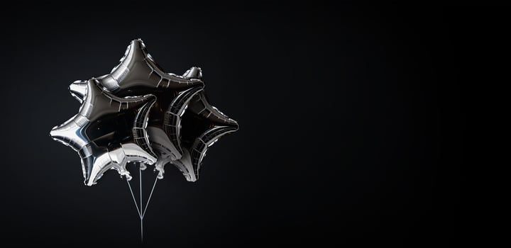 shiny silver star balloons on black background with copy space photo