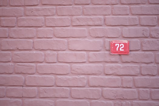 Beautifully Textured Pink Brick Wall Featuring the House Number 72 Prominently Displayed photo