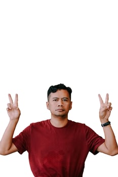 Southeast Asian man making a 'peace' sign with two fingers, symbolizing the number two photo