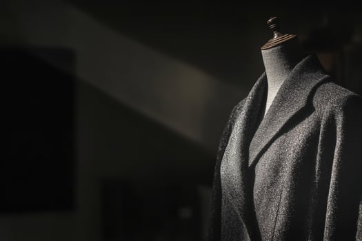 Elegant silhouette of a gray coat on a mannequin in soft lighting photo