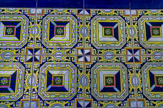 A collection of decorative ceramic tiles displays an array of intricate patterns and vibrant colors, including blues and greens photo