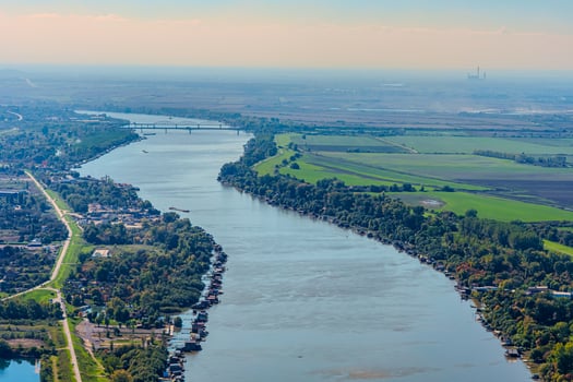Aerial view of valley with farm fields, pond and Danube river. High quality photo