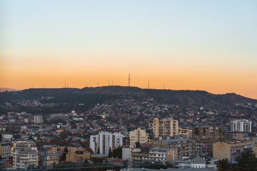 Golden hour over Tbilisi with a stunning view of city skyline and the surrounding mountains photo