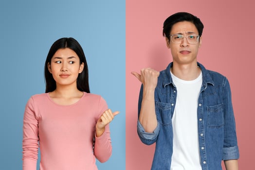 Disrespect in relationships. Annoyed asian man and woman pointing at each other over grey background photo