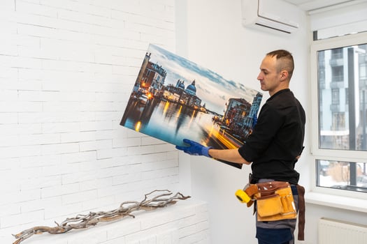 repairman master holds a photo canvas