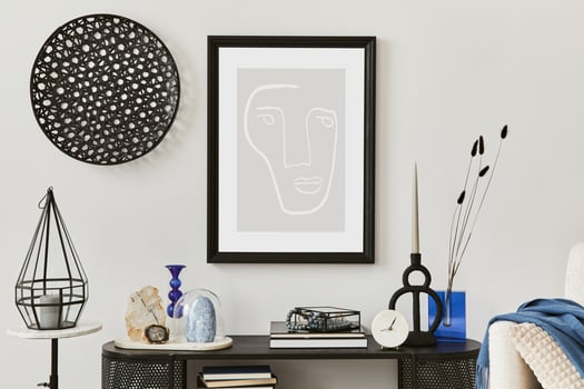 Stylish living room interior design with console, armchair and mock up poster frame. Candles, gemstones and vintage personal accessories. Copy space. photo