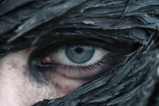 Mysterious eye peering through dark foliage photo