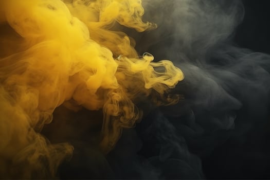 Swirling yellow smoke on black background photo