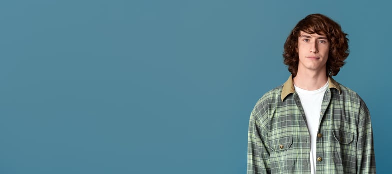 Serious young guy in casual clothes on turquoise background photo