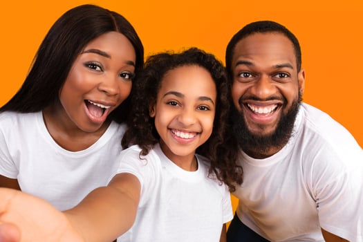 Portrait of happy african american family taking a selfie together. Excited parents posing with their daughter and smiling at camera, point of view. Bonding And Lifestyle Concept. photo