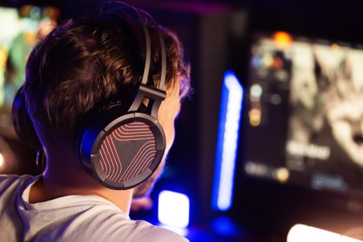 Gamer in headset plays game PC Computer club Real-time strategy multiplayer online competition. Esports tournament skill. Professional cyber sport championship. Modern gaming equipment earphones photo