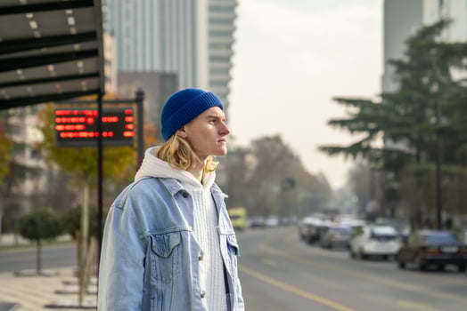 Pensive stylish trendy hipster guy looking into distance, waiting for taxi, bus photo