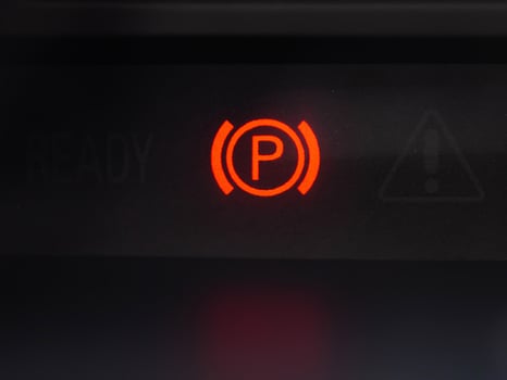 Red parking brake icon on the dashboard of a car. Brake failure. Close-up photo