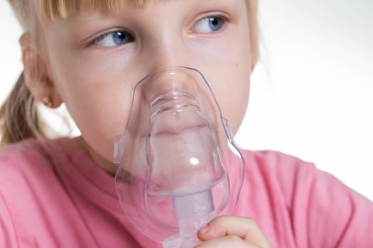 A 5-year-old girl breathes into an inhaler to dilute sputum in case of lung diseases. Treatment of cough in children. Nebulizer therapy photo