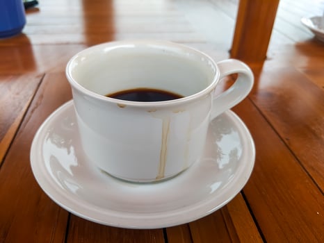 A used coffee cup with a striking coffee stain on a wooden table photo