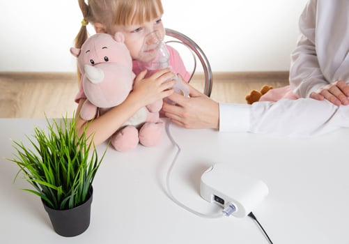 A 5-year-old girl breathes into an inhaler to dilute sputum in case of lung diseases. Treatment of cough in children. Nebulizer therapy photo