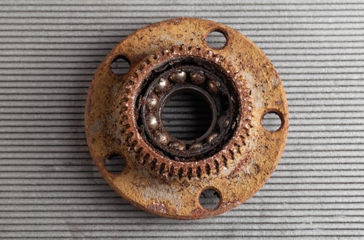 Old rusty wheel hub with a broken bearing. Bearing jamming. Automotive Part, close-up. photo