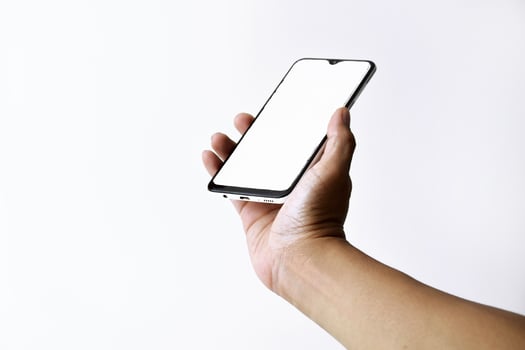 Male hand shows the screen of a mobile smartphone which has a white screen photo