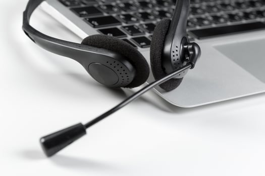 call center support concept. headset on keyboard computer laptop photo